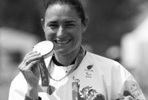 An image of Dame Sarah Storey at the olympics holding her medal.