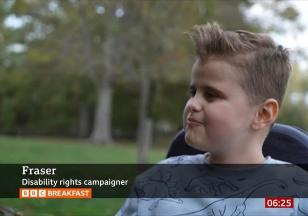 Image shows a screen shot of Fraser, age 10 at the time, appearing on BBC Breakfast. He is described in the BBC name banner as a 'Disability Rights Campaigner'.