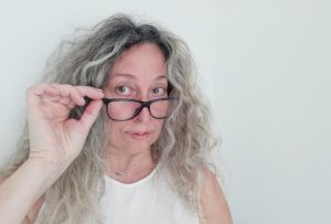 Woman with grey hair and glasses.