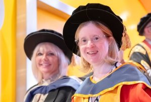 Jen Blackwell in graduation gown with her main support Donna Wheeldon behind her